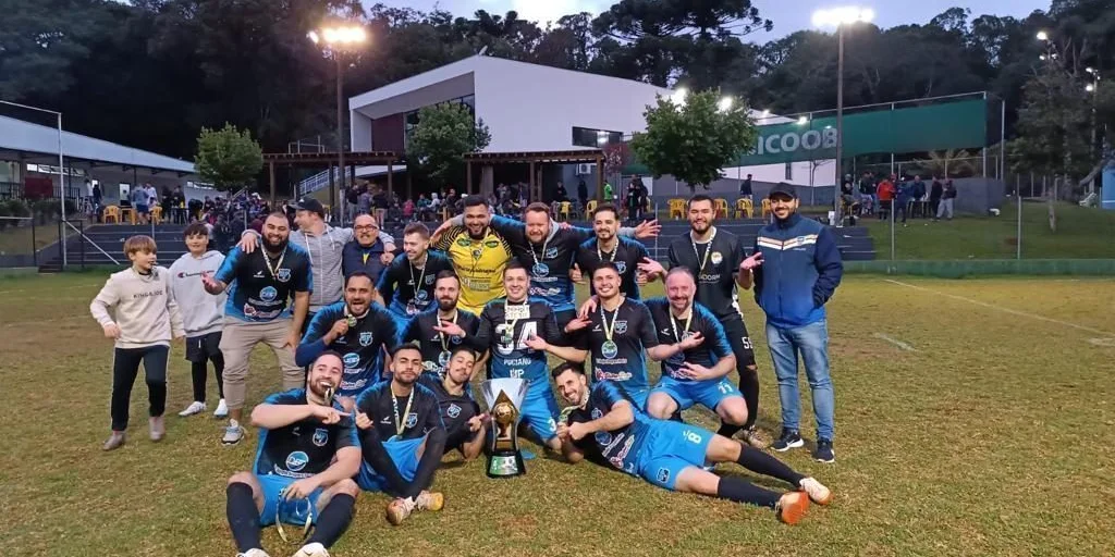 Equipe do clube comemorando com o troféu no campo